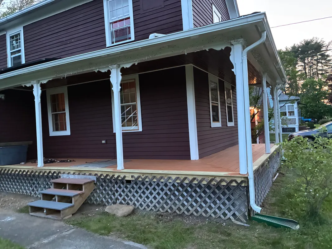 New wooden deck and stairs being installed on a brown house.