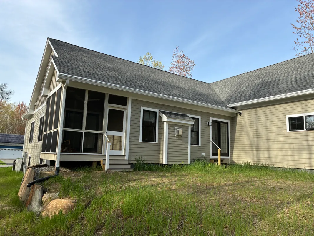 Exterior of a tan siding house with a gray shingled roof.