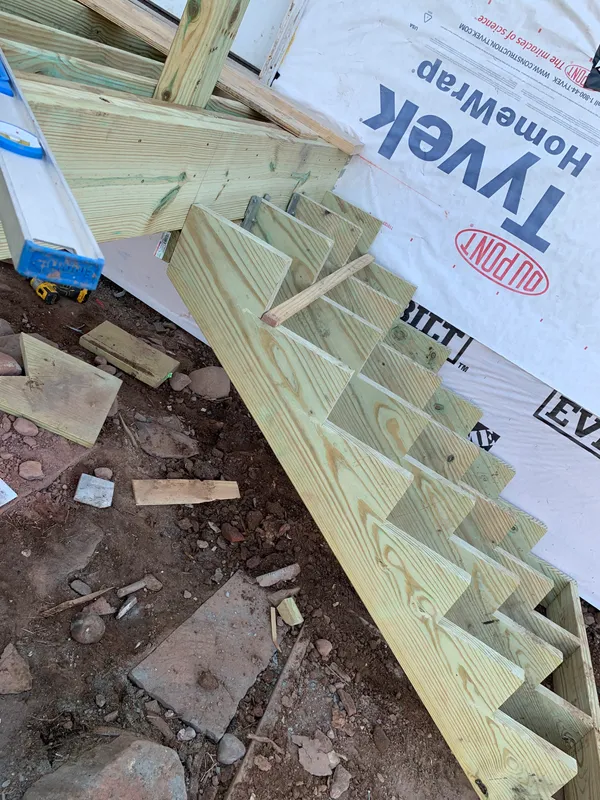 Wooden roof rafters and Tyvek house wrap during a construction project.